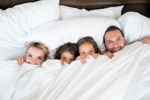 Schlechter Schlaf macht nicht nur müde Link führt zu einem Blogbeitrag zum Thema "gesund Schlafen", Bild zeigt eine Familie im Bett.
